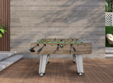 Foosball table outdoors against a wooden wall